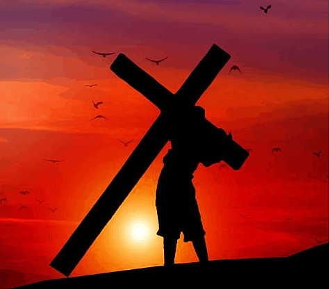 Man carrying cross at sunset